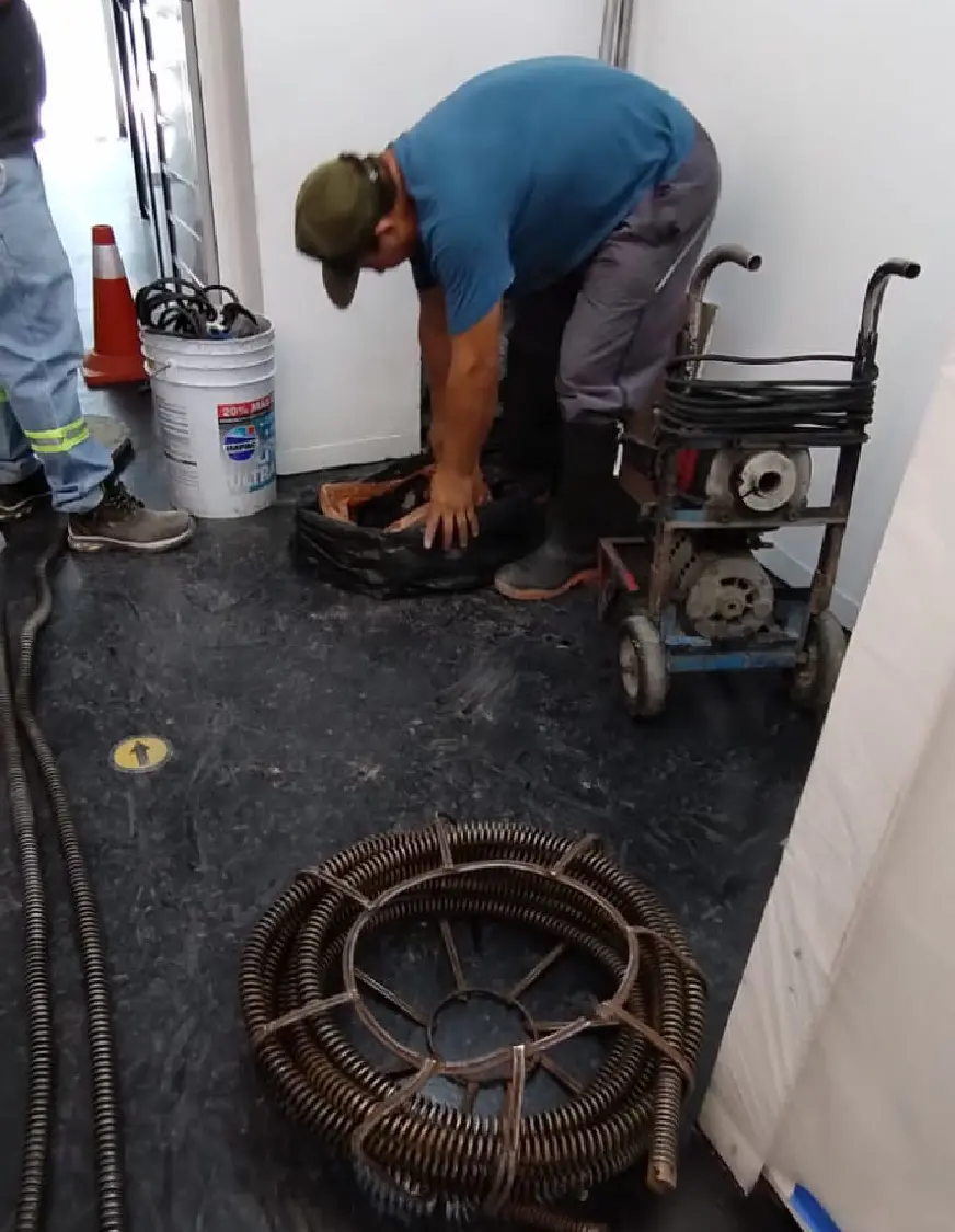 Técnico especializado en destapacaños trabajando junto al equipo electrico y un rollo de rotosondas